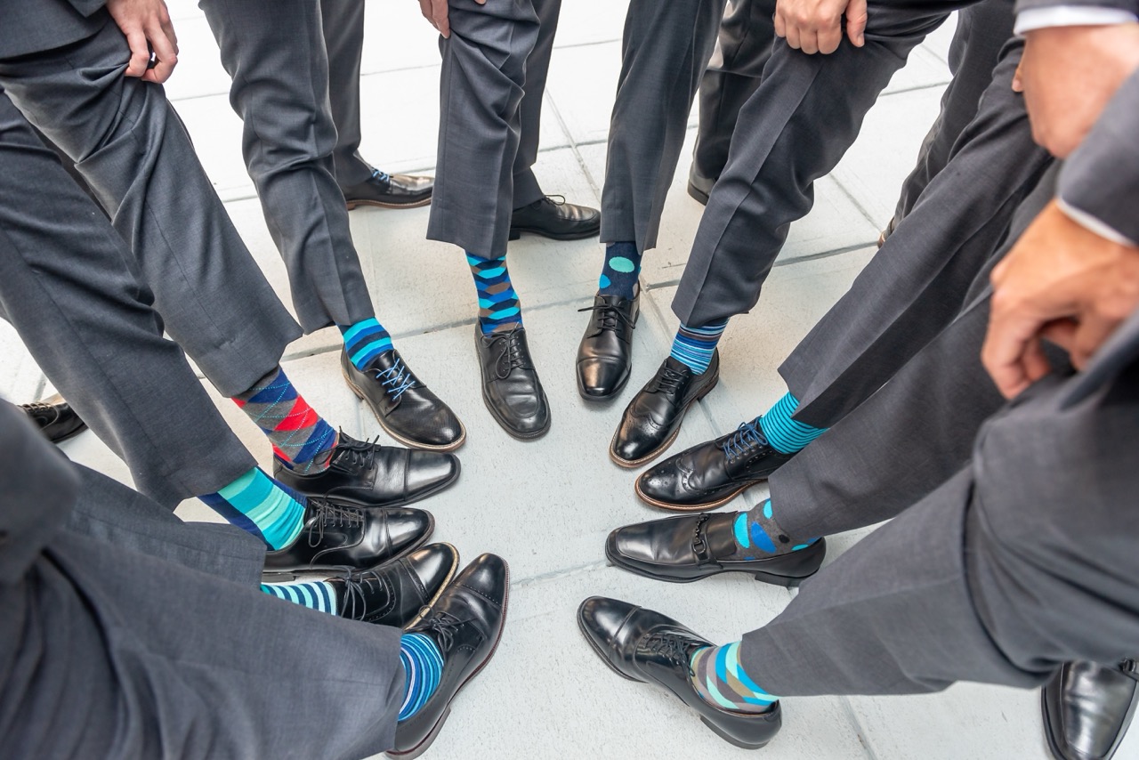 Groomsmen showing off matching socks